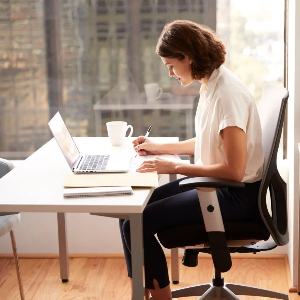 Sitting at a desk with a laptop and notebook